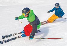 Skiers carving a groomer